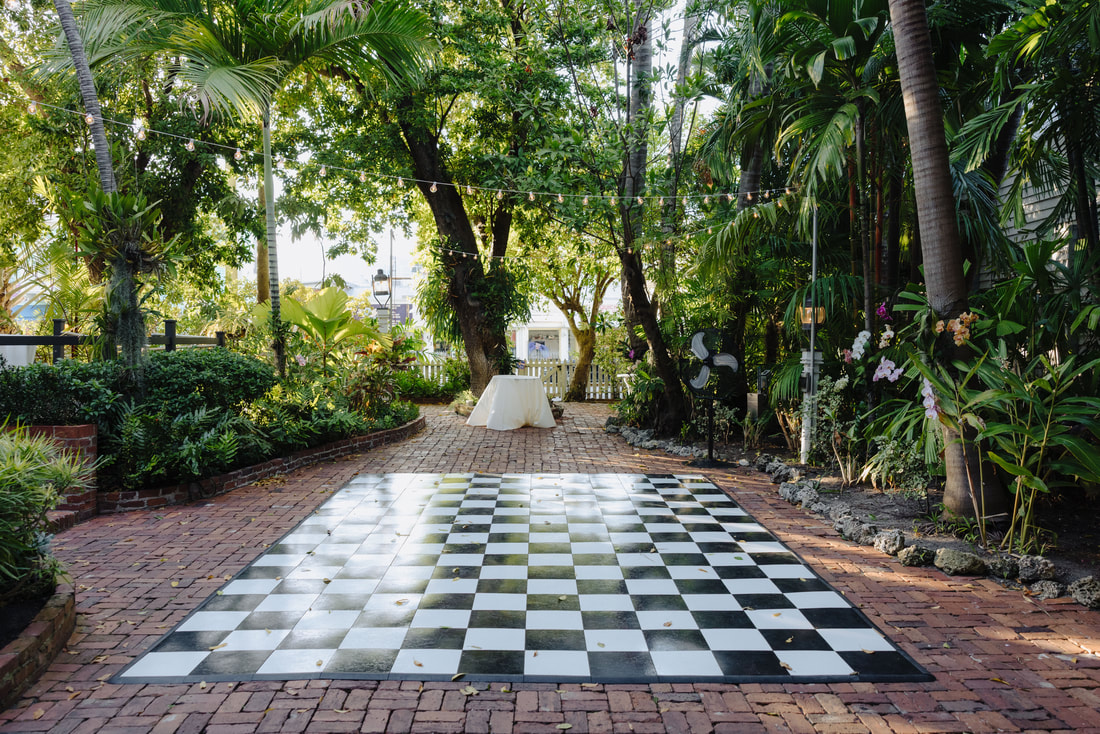 Floral arch and tropical details at outdoor Audubon House wedding ceremonyPicture
