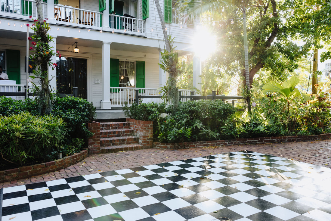 Floral arch and tropical details at outdoor Audubon House wedding ceremony Picture